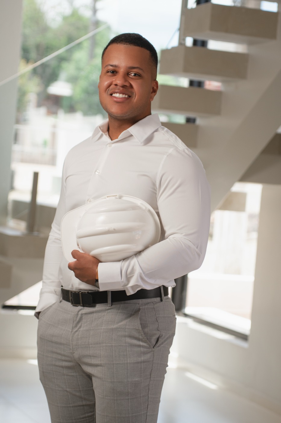 Gabriel Flores, arquiteto, segurando capacete numa obra